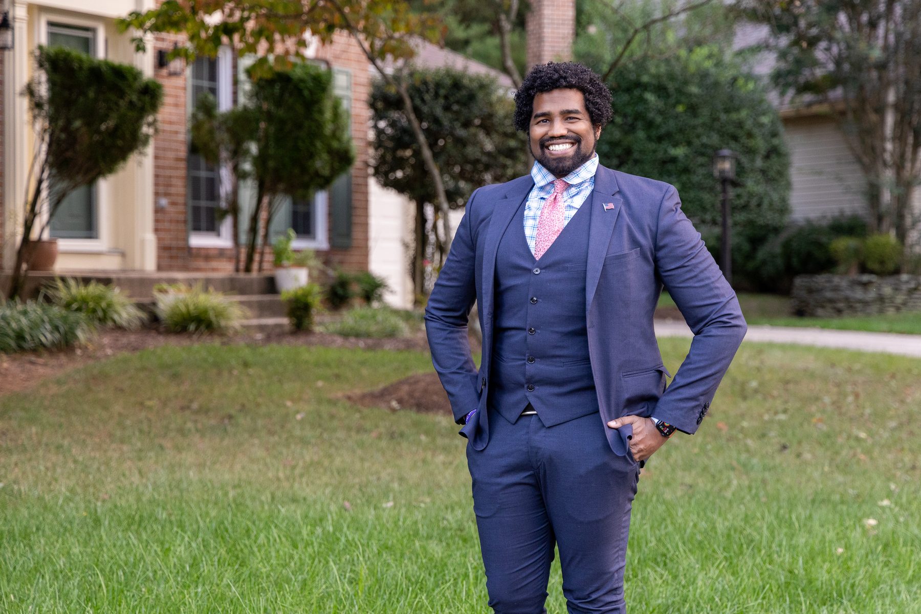 Preston Thomas standing in a Bowie neighborhood wearing a navy suit